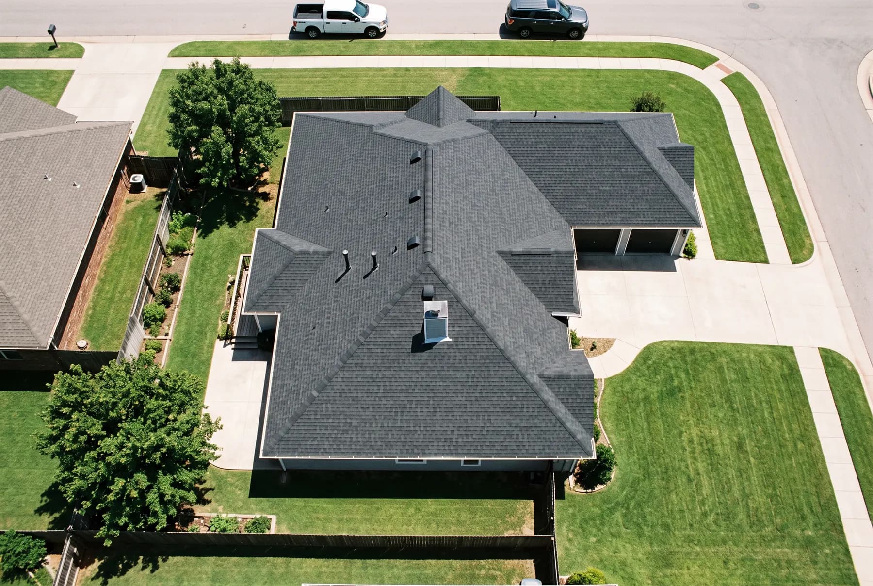 An aerial view looking straight down at a suburban house roof showing the full shingle plane.
